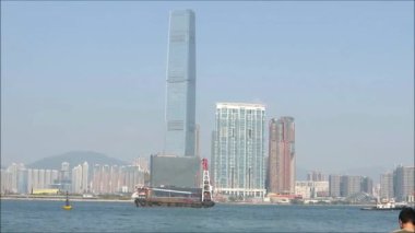 Victoria Limanı 'ndaki Dredger. Viktori Limanı 'nda yelken açan Kwloon siluetine karşı Dredger gemisi, Hong Kong