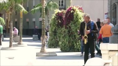 Cadiz, Spain - March 30, 2019: Street buskers entertaining in sunny Cadiz square. Man playing clarinet in sunny Cadiz square, Andalusia