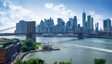 Manhattan Köprüsü 'nden Manhattan ve Brooklyn Köprüsü' nün aşağısında yazın mavi gökyüzü var.