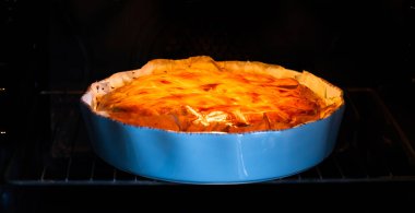 Fırında fırınlanmış patates turtası, mavi seramik turta tavasında.