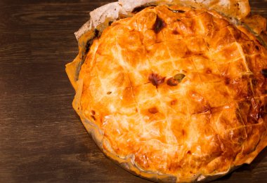 Ahşap bir masada fırında patates turtası.