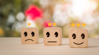 İyi bir iş derecelendirme deneyimiyle müşteri hizmetleri sektörün en iyisidir. Memnuniyet anketi kavramı. Tahta bir küp üzerinde, gülümseyen bir yüz seç..