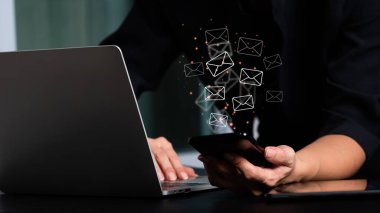 Cep telefonu tutan bir kadın ve e-posta ikonlu bir dizüstü bilgisayar. E- posta ve konseptlerle bağlantı kur