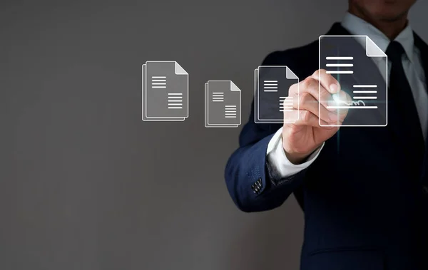 A businessman signs an e-document with a pen on a virtual notepad on a virtual screen.E-signing, electronic signature, document management, and the paperless office idea.