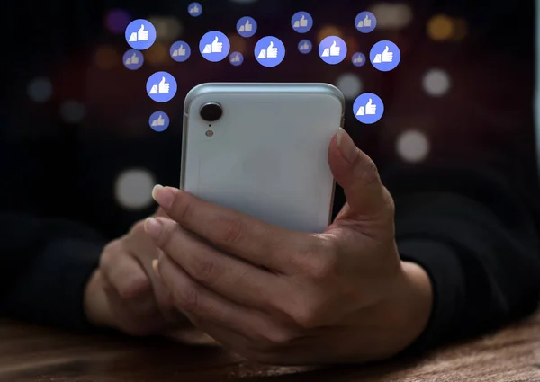 Akıllı telefonuyla mesaj, e-posta, yorum ve yıldız bildirim düğmelerini akıllı telefon ekranının üstünde kullanarak başkalarıyla iletişim kurmak ve internet üzerinden mesaj atmak isteyen bir kadın.