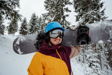 Güvenlik gözlüğü takan kayak ekipmanlı bir adam. Kış sporu macerası. Snowboardcu dağda yürüyüş yapıyor. Serbest bırakmak için toz arıyoruz.