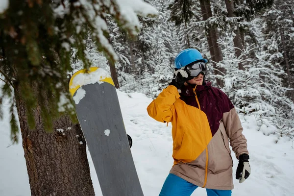 Sporty zimowe i rekreacja, rekreacja na świeżym powietrzu. Facet w sprzęcie narciarskim, w okularach ochronnych. Snowboarder człowiek wędrówki w górach — Zdjęcie stockowe