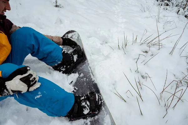 Snowboardzista siedzący samotnie w śniegu, górski odkryty, sporty zimowe. — Zdjęcie stockowe