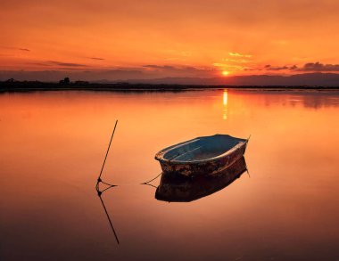 Gölde gün batımı bir tekneyle