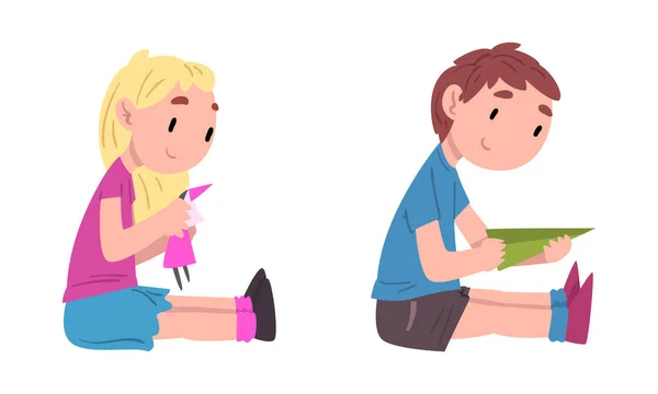 Liten gutt og jente som sitter på gulvet og leker med dukke- og papirplansjen. – stockvektor