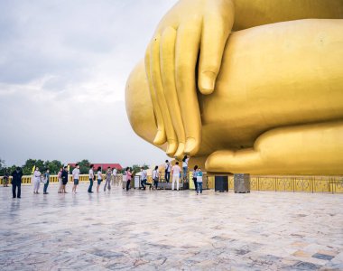Angthong, Tayland-14 Kasım 2021: Birçok turist Wat Muang, Ang Thong Eyaleti, Tayland 'daki büyük altın Buda heykeline saygılarını sunmak için sırada bekliyor.