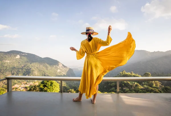 Güzel sarı elbiseli Asyalı kadın turist, güzel gökyüzü ve doğa dağları, Chiang Rai, Tayland.