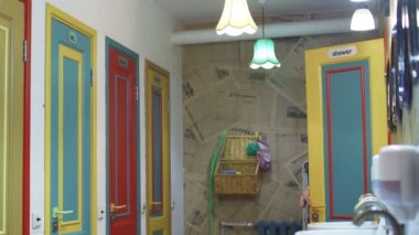 Genç bir kadın sabah kendini yukarı çeker ve bir otelde aynada kendine bakar.