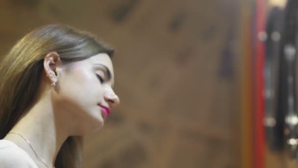 Vista lateral de una mujer usando lápiz labial para maquillaje delante de un espejo, una mujer feliz usando cosméticos para la belleza — Vídeo de stock