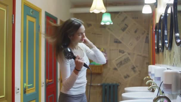 Молодая женщина вытирает волосы феном в отеле — стоковое видео