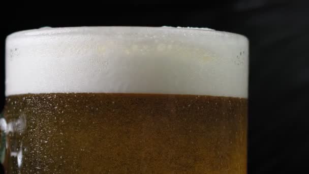 Birra leggera fredda in un bicchiere con gocce d'acqua. Primo piano della birra. — Video Stock