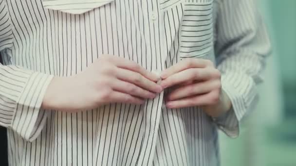 Жіночі руки натискають кнопки на смугастій блузці, крупним планом — стокове відео