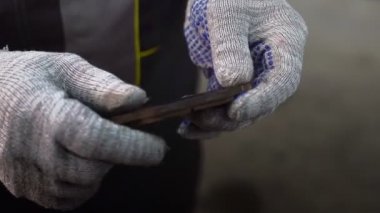 Arabadaki eskimiş fren yastıkları bir oto tamircisinin elinde, yakın plan..