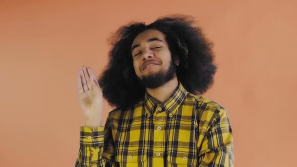 Bla, bla, bla. Un afro-americano annoiato, che fa gesti con un gesto Blah-Blah, stanco di conversazioni e informazioni poco interessanti, che posa su uno sfondo arancione — Video Stock