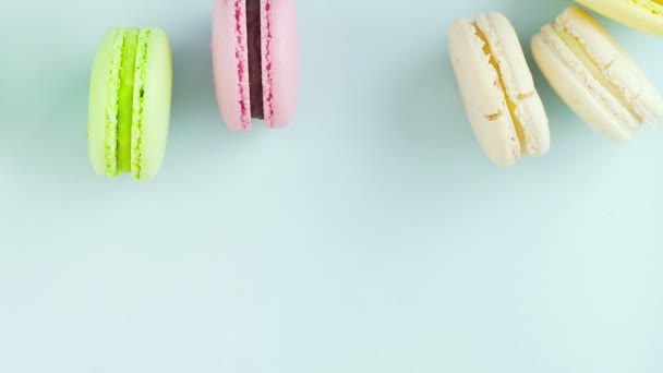 Horní pohled na pestrobarevné francouzské Macarons cookies na pastelově modrém pozadí