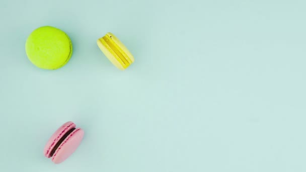 Vue de dessus des biscuits Macarons français multicolores et une tasse de café sur un fond bleu pastel — Video