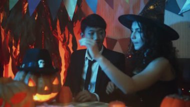 Cadılar Bayramı 'nı kutlayan bir grup arkadaş birlikte gülüp sohbet ediyorlar.