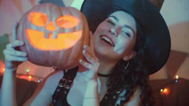 Una chica con un disfraz espeluznante con una Jack-o-linterna posa para la cámara en Halloween — Vídeo de stock