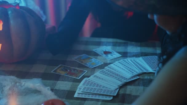 Egy baráti társaság tippel a kártyán Halloweenkor. A kártyák jövendölése — Stock videók