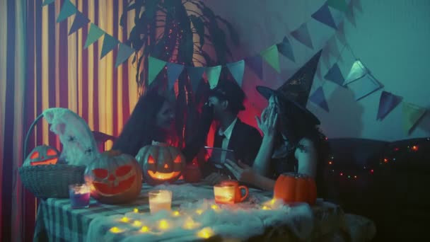 Um grupo de amigos celebra o Halloween fazendo um ao outro uma maquiagem assustadora — Vídeo de Stock
