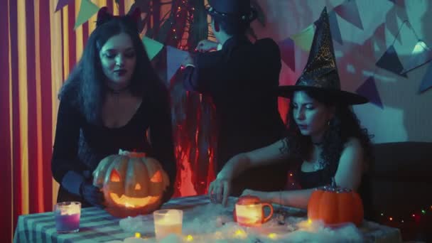 Skupina přátel v úchylných kostýmech zdobí pokoj na Halloween. Slavíme Halloween — Stock video