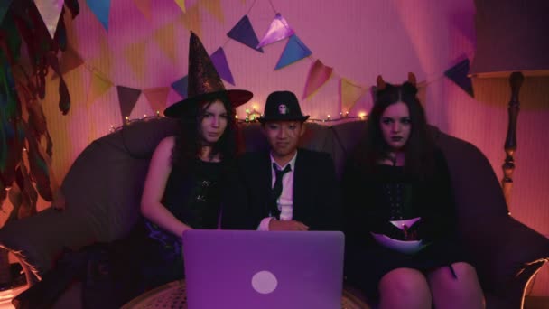 Un grupo de amigos está viendo una película en una computadora sobre Halloween. Historias de horror — Vídeo de stock