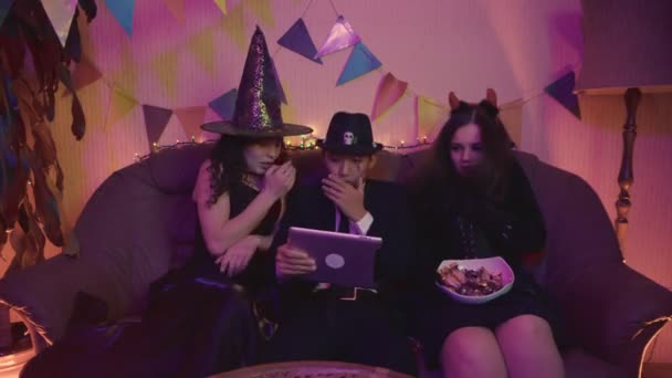 Een groep vrienden kijkt een enge Halloween film op een tablet. Angst — Stockvideo