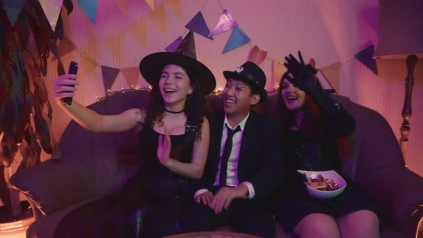 Un groupe d'amis en costumes effrayants, communiquer par lien vidéo via téléphone et rire sur Halloween — Video