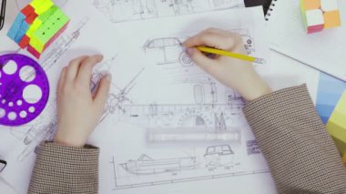 Üst görünüm bir kadın tasarımcının elleri bir Rubiks küpüyle bir bulmacayı çözer. Küp bulmacası, bir bulmaca oyunu.