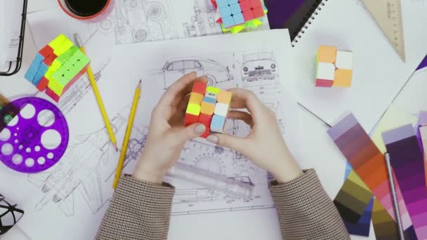 Top pohled na ruce návrhářky vyřešit puzzle s Rubiks kostkou. Kostka puzzle, puzzle hra. — Stock video