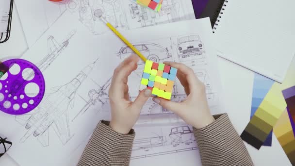 Руки дизайнера решают головоломку кубиком Рубикса. Куб головоломка, игра-головоломка. — стоковое видео