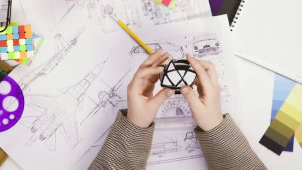 여성 디자이너의 맨 위 뷰는 루빅스 큐브 로 퍼즐을 풀 수있다. 큐브 퍼즐, 퍼즐 게임. — 비디오