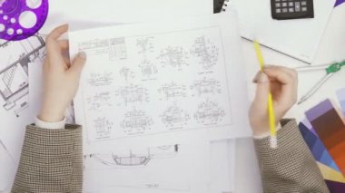 Üst görüşlü kadın elleri çizimler yapar ve her şeyi öfkeyle siler. Tasarımcı.