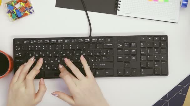 Vista superior de una mujer utiliza un teclado y vierte té directamente en el teclado — Vídeos de Stock