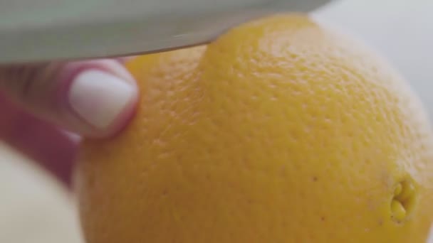 Κόβοντας ένα πορτοκάλι με ένα μαχαίρι κουζίνας από κοντά — Αρχείο Βίντεο