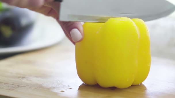 Close-up of slicing sweet pepper with a kitchen knife — Stock Video