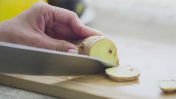 Резать свежий корень имбиря на деревянной доске крупным планом — стоковое видео