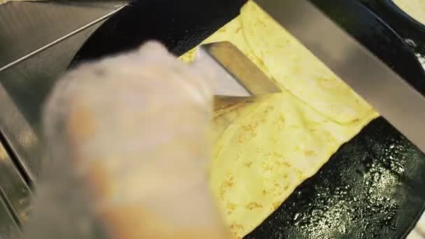 Ovanifrån av matlagning en rysk pannkaka på en professionell stekpanna i köket — Stockvideo