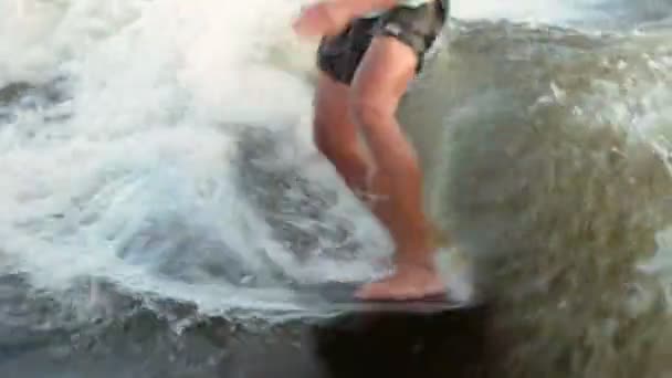 Surfař skákající na wakeboardu. Zkušený wakeboarder rozstřikuje do kamery kapky vody. — Stock video