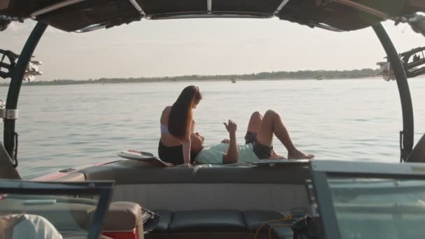 一个男的和一个女的坐在一艘摩托艇上，一边说话，一边看着远方。浪漫的气氛. — 图库视频影像