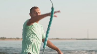 Wakeboard 'a atlayan bir sörfçü. Deneyimli bir wakeboardcu kameraya su püskürtür..