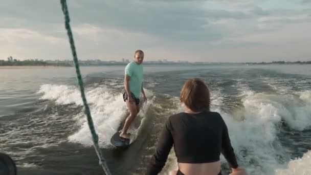 Surfer skaczący na desce. Doświadczony wakeboarder spryskuje kamerą krople wody. — Wideo stockowe