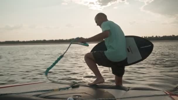 Een man op een motorboot met een wakeboard — Stockvideo