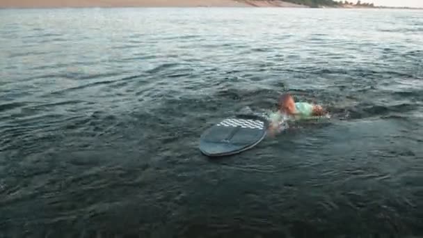 Un hombre nada en un wakeboard y sonríe — Vídeo de stock