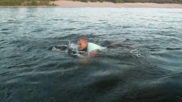 Un homme nage sur un wakeboard et sourit — Video